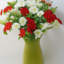 A pale green vase containing red and white flowers